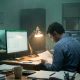 Late-night tax season scene inside a small CPA firm with monitors and paperwork