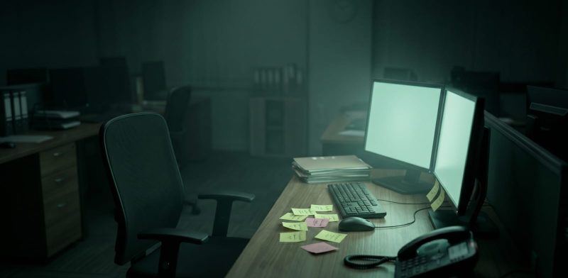Empty IT support desk in a small CPA firm at night with monitors still glowing